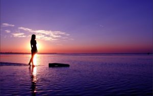 woman_standing_on_the_beach_at_sunset-wide